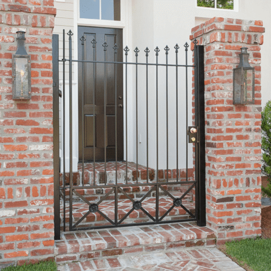 Custom brick entryway with wrought iron gate and lantern lighting in Cary, NC by Corner Solutions.