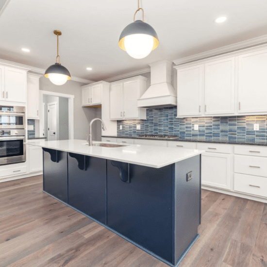 Cary NC kitchen renovation with white cabinetry, navy island, quartz countertops, engineered hardwood flooring, and modern tile backsplash.