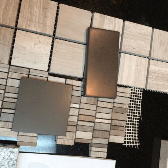 Bathroom tile selection in Cary NC featuring a coordinated board of stone-look tile, mosaic accents, and finish samples. Corner Solutions NC aligns flooring, wall tile, and hardware tones for a unified design.